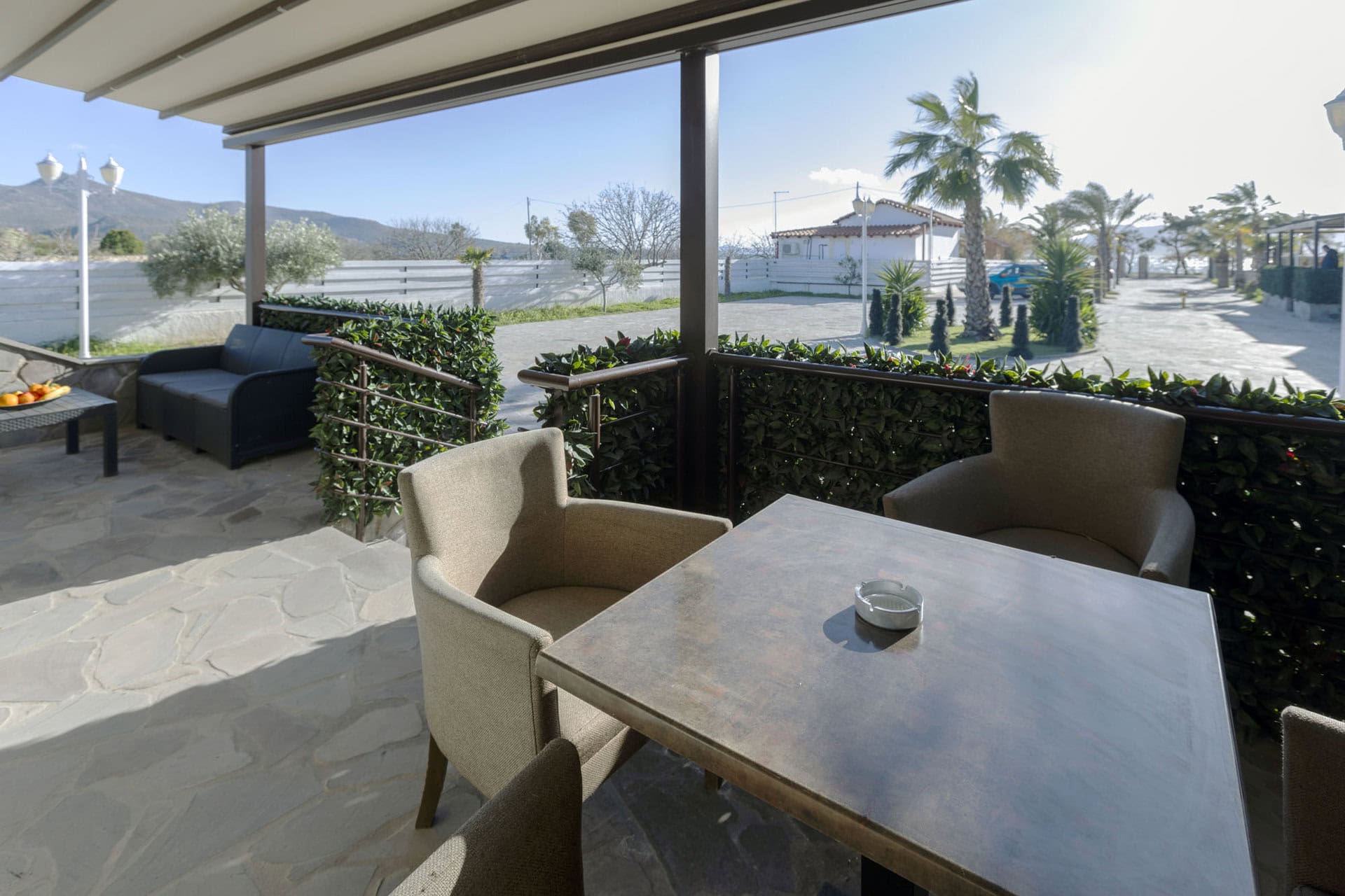 Covered outdoor dining table on the terrace of Bungalow Athena at Adonis Aegina Bungalows